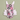 A children's one-piece romper with a playful donut print and ruffled details, laid flat on a solid sage green background. The design features various pink, black, and white donuts with colorful sprinkles, black-and-white stripes, and white ruffles decorated with pink donuts and sprinkles.