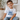 Child wearing a 'Promoted to Big Brother' shirt sitting on a couch.