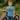 Child wearing a blue 'big brother' t-shirt standing next to a bicycle outdoors.