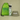 A personalized swim-themed gift set featuring a bright lime green drawstring bag with 'MICHELLE'S SWIM BAG' text, a clear water bottle with green dinosaur graphics and 'ARCHIE' printed vertically, and an olive green bucket hat with 'Michelle' embroidered in white.
