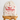 A beige canvas drawstring bag with red printed text reading 'Meri Kirihimete Christmas is coming' and red starburst accents, displayed on a wooden stool against a light gray background.