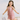 Young girl in a pink art deco dress holding a silver handbag against a light background