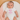 Baby wearing a white onesie with 'New to the Crew' pink text, lying on a soft surface.