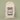 A beige drawstring gift bag with a festive black and gold graphic that reads 'Santa Claus Delivery For Michelle' and 'Santa Approved', shown against a solid sage green background.